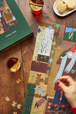 Bundle Up 500 Piece Puzzle by Ordinary Habit with person holding a piece