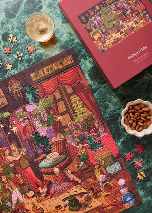 Magic of the Season 1000 Piece Puzzle by Ordinary Habit on a table with snacks